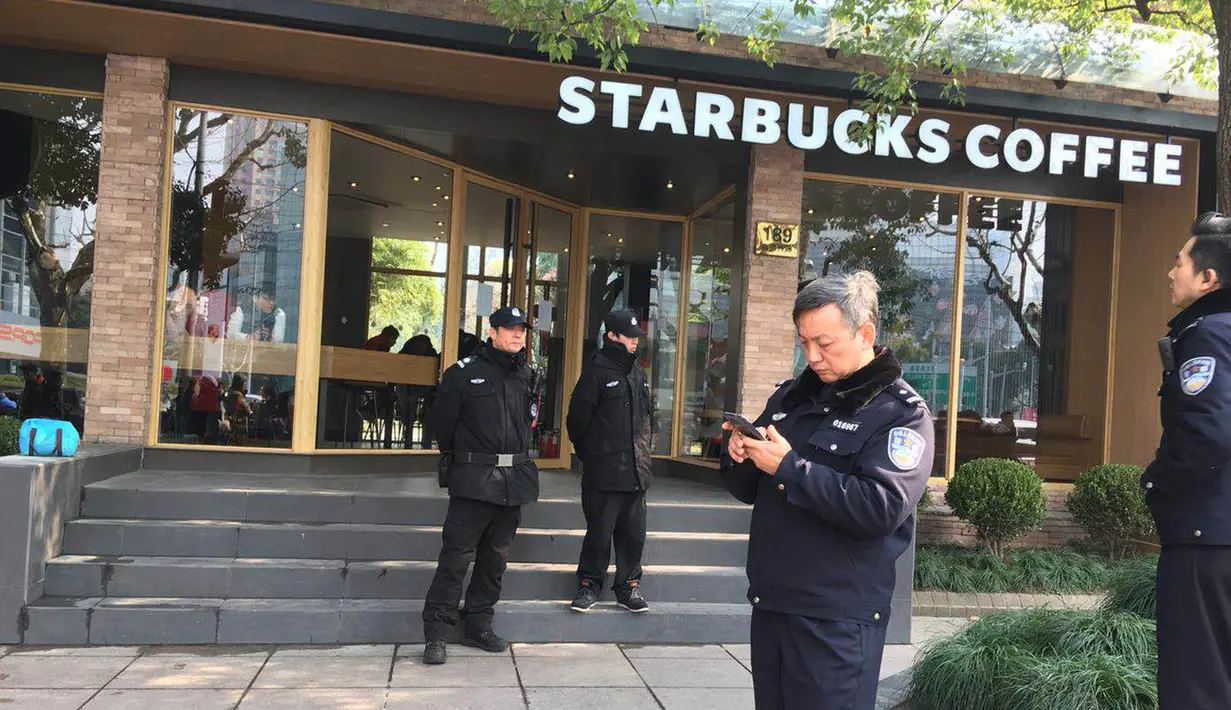 Petugas kepolisian berjaga di dekat lokasi  van yang menabrak pejalan kaki di trotoar daerah sibuk di Shanghai, Jumat (2/2). Sejumlah video dan foto yang beredar di media sosial memperlihatkan beberapa orang berbaring tak berdaya usai insiden. (AP Photo)