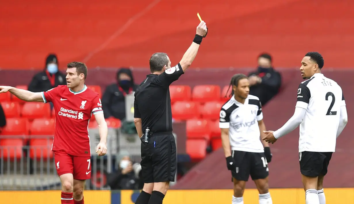 Wasit Kevin Friend memberikan kartu kuning kepada pemain Fulham Kenny Tete pada pertandingan Liga Inggris di Stadion Anfield, Liverpool, Inggris, Minggu (7/3/2021). Liverpool takluk 0-1 dari Fulham. (Paul Ellis/Pool via AP)