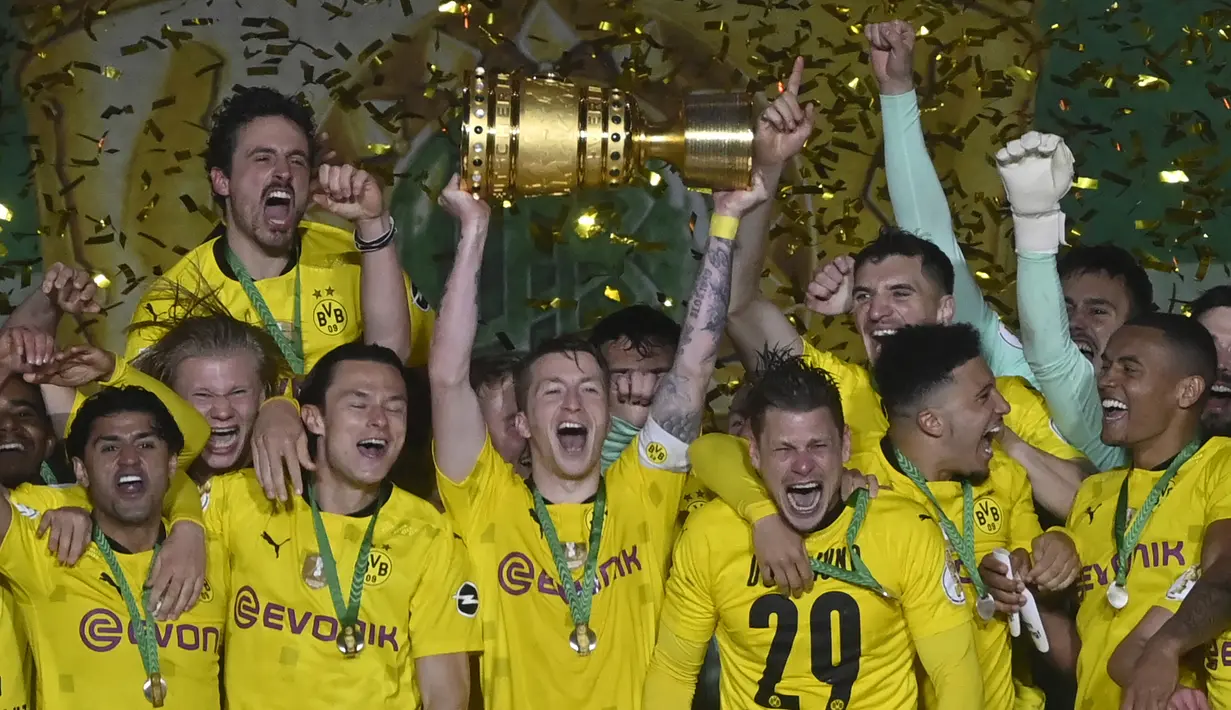 Striker dan kapten Borussia Dortmund, Marco Reus (tengah) mengangkat trofi DFB Pokal di tengah-tengah rekan setim usai kemenangan 4-1 atas RB Leipzig dalam partai Final DFB Pokal 2020/2021 di Olympiastadion, Berlin, Kamis (13/5/2021). (AFP/John MacDougall/Pool)