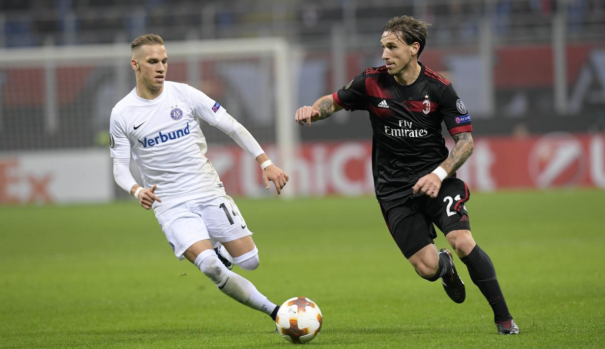 Pemain AC Milan, Lucas Biglia (kanan) mencoba melewati adangan pemain Austria Wien, Christoph Monschein pada laga grup D Liga Europa di San Siro stadium, Milan, (23/11/2017). Milan menang telak 5-1. (AFP/Miguel Medina)
