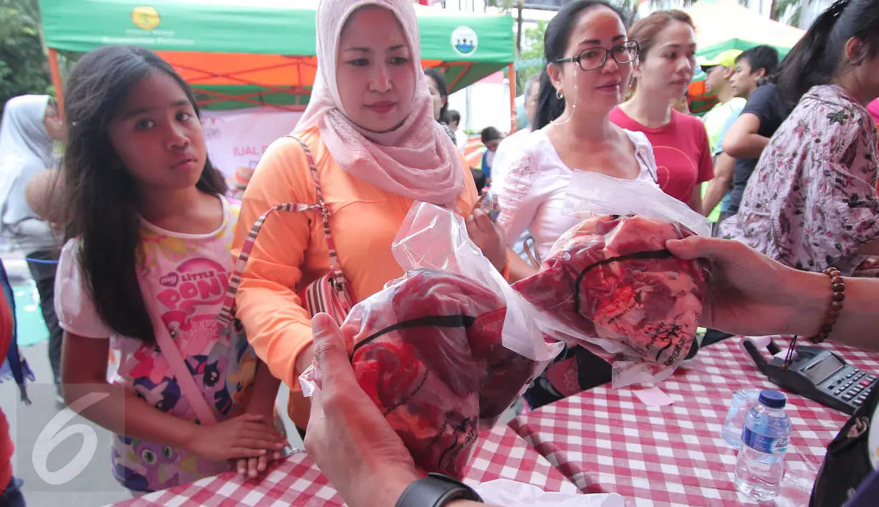Warga tengah membeli daging murah di Jakarta, Minggu (21/2). Kementerian Pertanian (Kementan) bersama PT Berdikari (Persero) menggelar operasi pasar dengan penjualan paket daging sapi lokal terjangkau. (Liputan6.com/Angga Yuniar)