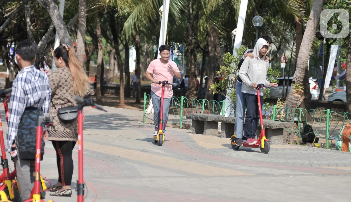 Pengunjung saat berkeliling menggunakan skuter listrik di Pantai Lagoon, Ancol, Jakarta, Rabu (9/10/2019). Pengelola Ancol kini menyediakan penyewaan skuter listrik berbasis aplikasi untuk pengunjung berkeliling kawasan pantai dengan tarif Rp.20.000 per 30 menit. (merdeka.com/Iqbal S. Nugroho)
