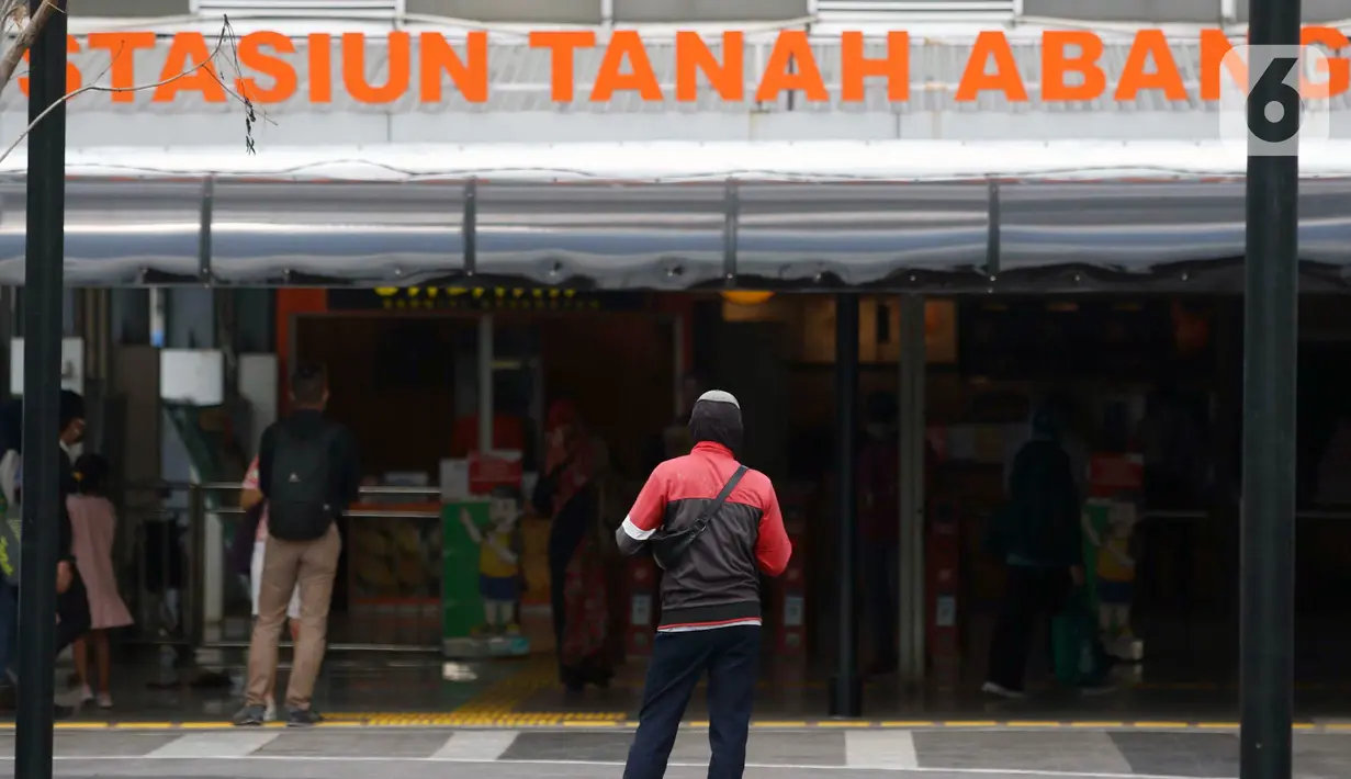 Warga berdiri di depan Stasiun Tanah Abang, Jakarta Pusat, Jumat (5/6/2020). Pengemudi angkot, bajaj, hingga ojek kini bisa menunggu penumpang yang baru turun dari kereta di jalur khusus angkutan umum. (Liputan6.com/Johan Tallo)