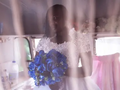 Memori berpose untuk sebuah potret setelah mendapatkan gaun pengantin yang pas di toko penyewaan pengantin di luar Pengadilan Magistrates di Harare, Zimbabwe pada 25 Agustus 2023. (JOHN WESSELS/AFP)