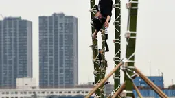 Para pemadam kebakaran berpakaian tradisonal memperlihatkan atraksi berbahaya berdiri di atas bambu saat perayaan Tahun Baru di Tokyo, Jepang, Jumat (6/1). Mereka memperlihatkan berbagai aksi-aksi mendebarkan di atas bambu. (Toshifumi KITAMURA/AFP)