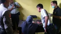 Ibunda Ahmad Muhazan alias Azan terduga pelaku teror Jakarta, Maemunah, saat akan diambil sampel DNA-nya oleh tim Dokkes Polri. (Liputan6.com/