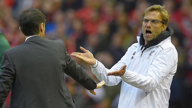 Pelatih Liverpool, Jurgen Klopp (L) melakukan protes kepada pelatih  Villarreal, Marcelino Garcia Toral pada laga leg kedua semifinal Liga Europa di Stadion Anfield, Liverpool, Jumat (6/5/2016)  dini hari WIB. (AFP/Lluis Gene)