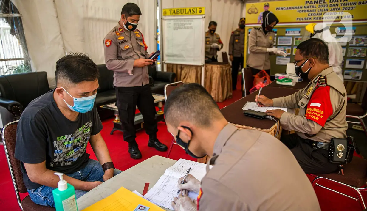 Polisi mendata warga saat rapid test gratis di Pos Pengamanan Natal 2020 dan Tahun Baru 2021 Polsek Kebayoran Lama, Jakarta, Selasa (29/12/2020). Rapid test itu dilakukan untuk membantu mengurai antrean warga saat tes di tempat lainnya. (Liputan6.com/Faizal Fanani)