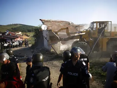 Aparat Kepolisian Bulgaria berjaga di lokasi penggusuran rumah di pinggiran kota Roma, Stara Zagora, (21/7/2014). (REUTERS/Stoyan Nenov)