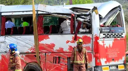 Petugas menyelidiki sebuah bus berisi mahasiswa asing yang mengalami kecelakaan di Jalan Raya AP7 dekat Kota Freginals, Spanyol, Minggu (20/3). Sedikitnya 13 penumpang tewas dalam insiden itu sementara puluhan lainnya luka-luka. (PAU Barrena/AFP)