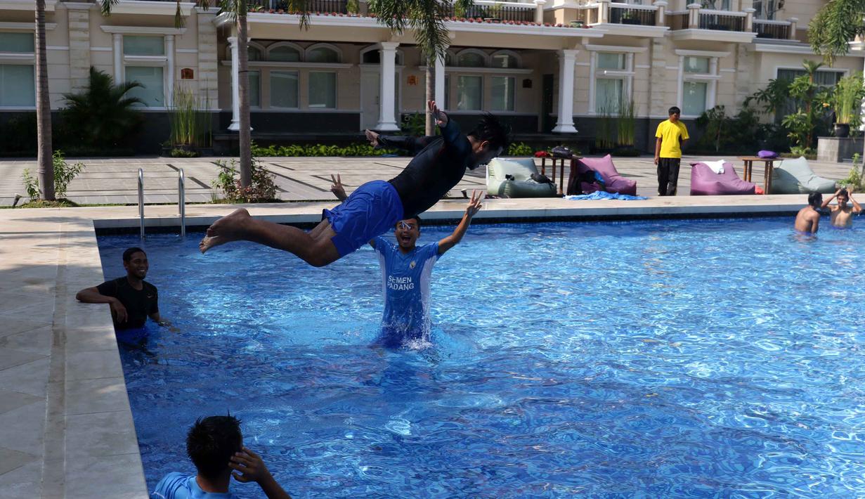 Seorang Pemain Semen Padang melompat ke kolam saat berenang bersama tim di Kolam Renang Hotel Adhiwangsa, Solo, Minggu(13/12/2015). (Bola.com/Nicklas Hanoatubun)