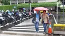 Pejalan kaki melintas menggunakan payung saat hujan mengguyur kawasan Jakarta, Senin (3/2/2020). Badan Meteorologi, Klimatologi, dan Geofisika (BMKG) merilis informasi peringatan dini cuaca ekstrem yang diperkirakan berlangsung hingga Rabu (5/2/2020) mendatang. (Liputan6.com/Angga Yuniar)