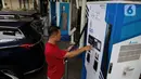Pemilik kendaraan melakukan pengisian daya kendaraan listrik di SKPLU, Jakarta, Minggu (5/1/2025). (Liputan6.com/Angga Yuniar)