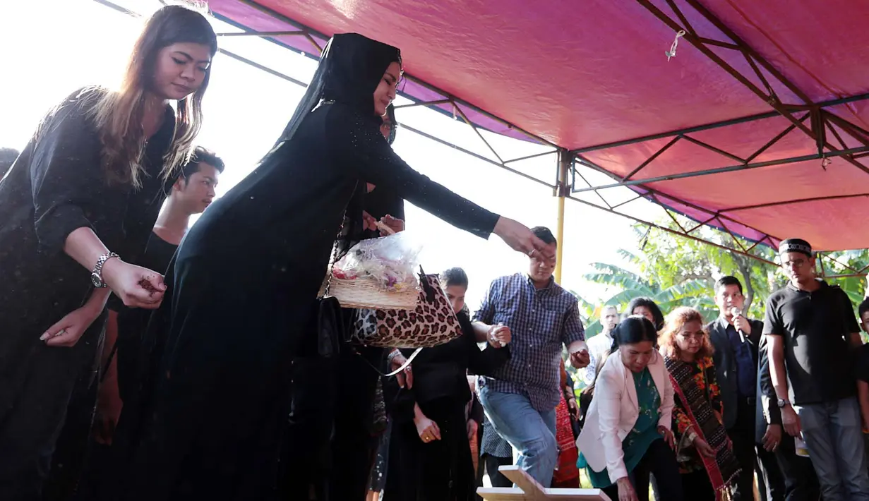 Jenazah dimasukkan ke liang lahat dengan peti warna putih. Setelah rata dengan tanah, Natalie terlihat menaburkan bunga. Natalie Sarah terlihat tak kuasa menahan air matanya saat tabur bunga. (Deki Prayoga/Bintang.com)