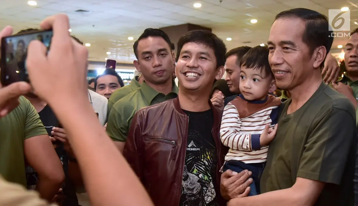 Warga foto bersama Presiden Joko Widodo dan cucunya Jan Ethes di mal Botani Square, Bogor, (8/12). Jokowi tiba pukul 20.10 WIB, Presiden menggendong Jan Ethes langsung menuju arena permainan anak "Fun World". (Liputan6.com/HO/Biro Pers Setpres)