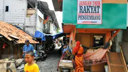 Spanduk penolakan penggusuran terpasang di kawasan permukiman Luar Batang, Penjaringan, Jakarta, Rabu (20/4). Mereka menolak pembongkaran tahap dua yang akan dilakukan Pemprov DKI pada Mei nanti. (Liputan6.com/Yoppy Renato)