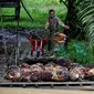 Seorang pekerja mengangkut cangkang sawit di atas rakit di sebuah perkebunan sawit di Sampoiniet, provinsi Aceh (7/3/2021). Kelapa sawit merupakan tanaman perkebunan yang memiliki produksi terbesar di Kabupaten Aceh. (AFP Photo/Chaideer Mahyuddin)