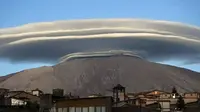 Awan lenticular yang terlihat di Sicily, Italia, terbentuk akibat adanya tiupan uap air melewati puncak gunung dan menetes pada sisi lain (Dailymail.com).