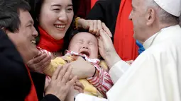 Paus Fransiskus menyapa jemaat dari China saat audiensi umum mingguan di Vatikan (18/4). Pada tahun 2016, di China umat Katolik terbelah antara mereka yang loyal pada Paus dan jemaat gereja resmi yang dikontrol pemerintah. (AP/Gregorio Borgia)
