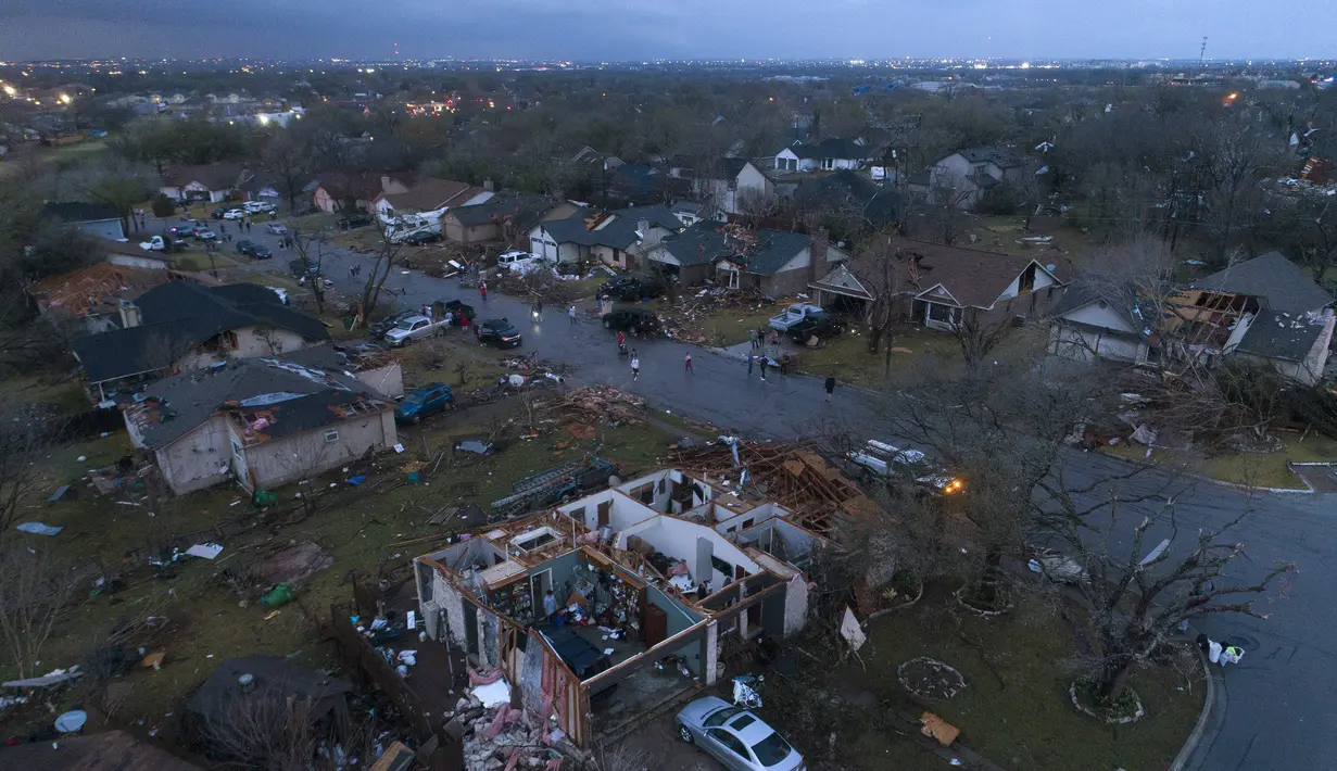 Puing-puing berserakan di tanah di sekitar rumah, yang rusak akibat tornado, di Oxford Drive dan Stratford Drive di Round Rock, Texas, Senin (21/3/2022). (Jay Janner/Austin American-Statesman via AP)