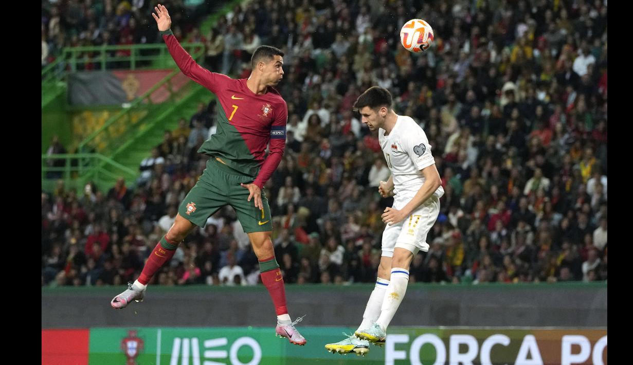 Pemain Timnas Portugal, Cristiano Ronaldo (kiri) berebut bola dengan pemain Timnas Liechtenstein, Noah Frommelt pada laga Kualifikasi Euro 2024 yang berlangsung di Jose Alvalade, Lisboa, Portugal, Jumat (24/03/2023) dini hari WIB. CR7 berhasil menorehkan rekor baru sebagai pemain dengan torehan caps internasional terbanyak dalam sejarah. Lewat 197 penampilannya bersama Selecao, ia berhasil melewati rekor striker Kuwait, Bader Al-Mutawa yang sebelumnya memimpin dengan 196 caps. (AP Photo/Armando Franca)