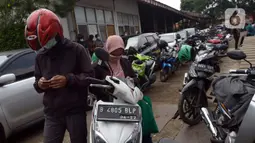 Warga antre untuk melakukan uji emisi kendaraan bermotor secara gratis di Bengkel Dinas Lingkungan Hidup DKI Jakarta, Kamis (4/11/2021). Uji emisi digelar untuk kendaraan bermotor berusia di bawah tiga tahun guna mengurangi pencemaran udara khususnya di DKI Jakarta. (merdeka.com/Imam Buhori)