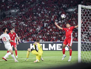 Pemain Timnas Indonesia, Rizky Ridho (kanan) melakukan penyelamatan dengan membuang bola saat laga lanjutan putaran ketiga Kualifikasi Piala Dunia 2026 melawan Bahrain di Stadion Utama Gelora Bung Karno (SUGBK), Senayan, Jakarta, Selasa (25/03/2025). (Bola.com/Bagaskara Lazuardi)