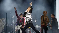 Penampilan Mick Jagger (tengah) saat konser Rolling Stones dalam tur 'No Filter' di Soldier Field, Chicago, Amerika Serikat, Jumat (21/6/2019). Jagger tampil memukau dengan aksinya yang energik di atas panggung. (Kamil Krzaczynski/AFP)