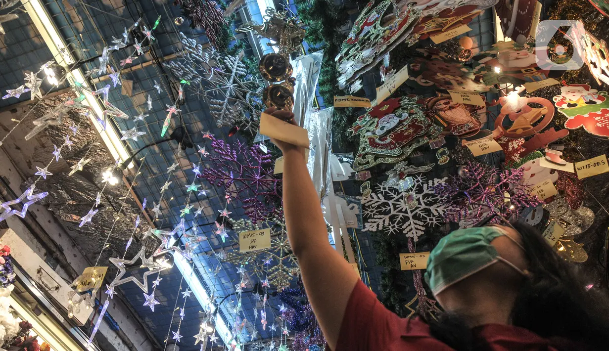 Pengunjung saat melihat pernak-pernik Natal di salah satu toko di Pasar Asemka, Jakarta, Kamis (9/12/2021). Meski masih berada di masa pandemi Covid-19, penjualan pernak-pernik Natal di Pasar Asemka mengalami peningkatan. (merdeka.com/Iqbal S Nugroho)