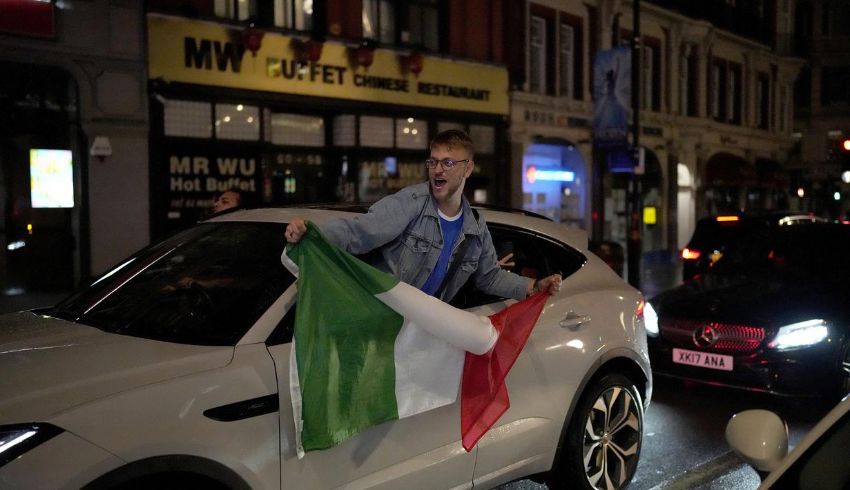 Pendukung Italia merayakan kemenangan di jalanan pusat kota London, Inggris pada Senin (12/07/2021), setelah Italia berhasil mengalahkan Inggris pada Final Euro 2020 yang berlangsung di Stadion Wembley. Italia mengalahkan Inggris 3-2 dalam adu penalti setelah bermain imbang 1-1. (AP/Matt Dunham)
