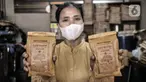 Pekerja menunjukkan kopi yang siap dipasarkan di toko kopi Sari Murni, Jatinegara, Jakarta Timur, Selasa (4/1/2021). Toko kopi yang berdiri sejak tahun 1952 ini juga dikenal dengan Kopi Cap Sedan. (merdeka.com/Iqbal S. Nugroho)