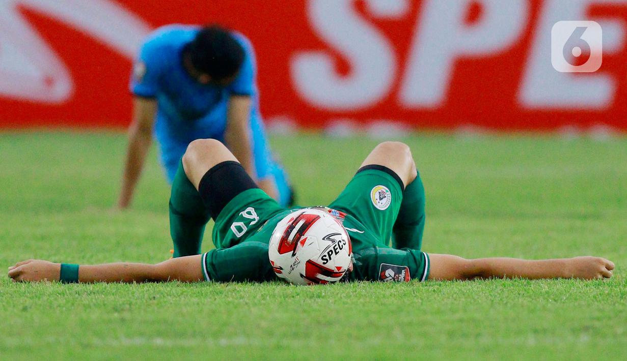 Pemain PSS Sleman, Derry Rachman, tergeletak usai pertandingan melawan Persela Lamongan pada laga Piala Menpora 2021 di Stadion Si Jalak Harupat, Bandung, Minggu (28/3/2021). PSS Sleman bermain imbang atas Persela Lamongan 0-0. (Bola.com/M Iqbal Ichsan)