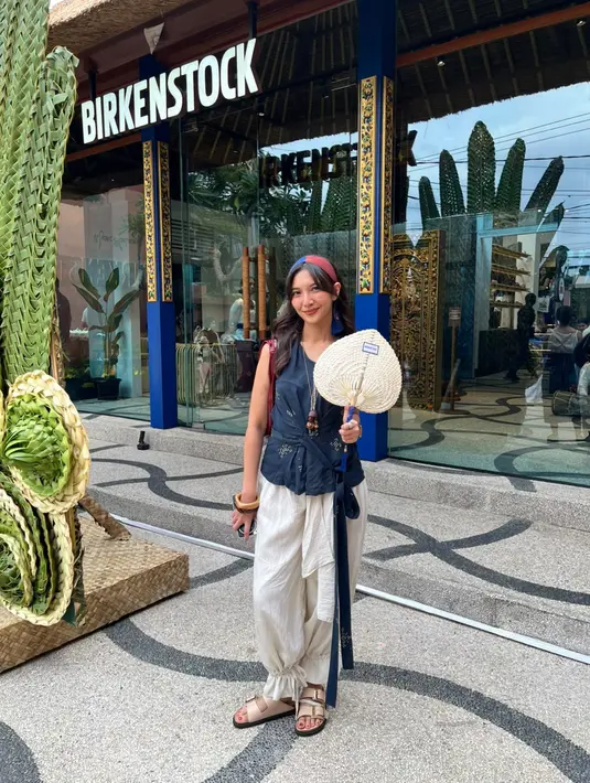 Sheila Dara hadir dengan Birkenstock Arizona double-strap berwarna beige yang serasi dengan celana berpotongan loose dan wrap top. / Foto: Fimela.com.