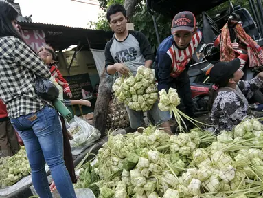 Warga membeli kulit ketupat untuk bahan membuat ketupat yang menjadi makanan khas di Hari Raya Idul Fitri, Jakarta, Senin (4/7). Jelang Hari Raya Idul Fitri, pedagang kulit ketupat mulai kebajiran pembeli. (Liputan6.com/Yoppy Renato)