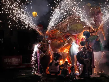Sejumlah patung tokoh kartun dibakar saat festival tradisional Fallas di Valencia, Spanyol (19/3). Masyarakat Valencia, Spanyol Timur, melepas musim dingin dan menyambut musim semi dengan menggelar festival tradisional Las Fallas. (AP/Alberto Saiz)