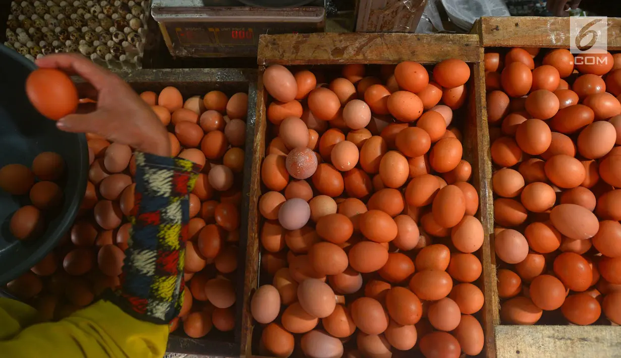 Penjual menunjukkan telur dagangannya di Pasar Minggu, Jakarta, Rabu (24/7). Harga telur ayam mengalami penurunan di angka Rp 26 ribu per kilo. (Merdeka.com/Imam Buhori)