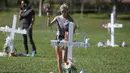 Seorang wanita menempatkan bunga di situs peringatan untuk menghormati korban pembunuhan massal di Sekolah Marjory Stoneman Douglas , Pine Trail Park, Florida (16/2). Sebanyak 17 orang ditembak di lokasi tersebut. (Mark Wilson / Getty Images / AFP)