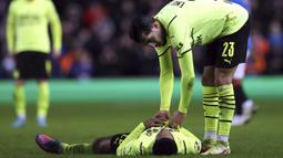 Gelandang Borussia Dortmund, Jude Bellingham (bawah) dihibur rekannya, Emre Can usai berakhirnya laga leg kedua play-off Liga Europa 2021/2022 menghadapi tuan rumah Glasgow Rangers yang berakhir imbang 2-2. Dortmund tersingkir setelah di leg pertama kalah 2-4. (AP/Scott Heppell)