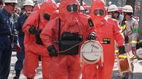 Petugas pemadam kebakaran memeriksa lokasi serangan gas sarin di Tokyo, Jepang, 20 Maret 1995. Anggota sekte kiamat Aum Shinrikyo meninggalkan kantung-kantung berisi racun saraf cair di jalur kereta yang melalui Tokyo. (JIJI PRESS/AFP)