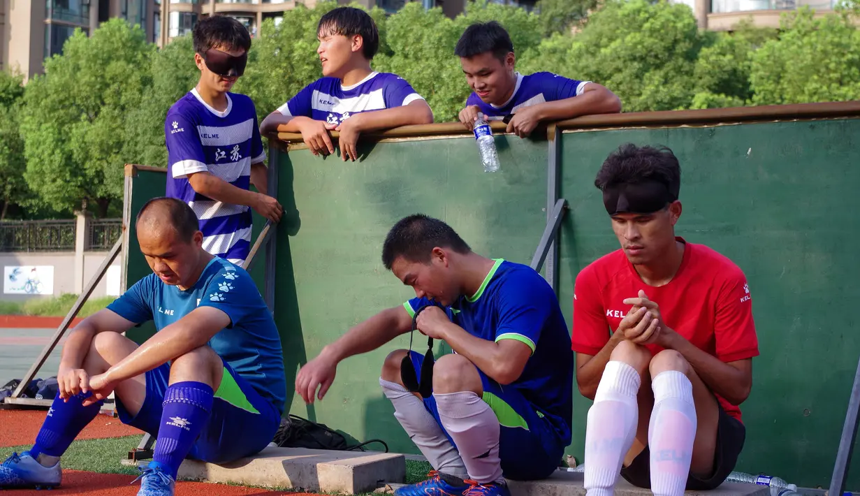 Pemain tim sepak bola tunanetra Provinsi Jiangsu beristirahat saat sesi pelatihan Nantong di provinsi Jiangsu timur China (19/8/2019). Semua pemain dari tim sepak bola tunanetra ini sudah dalam perdagangan pijat. (Cheng Yajing/Jiangsu Provincial Blind Football Team/AFP)