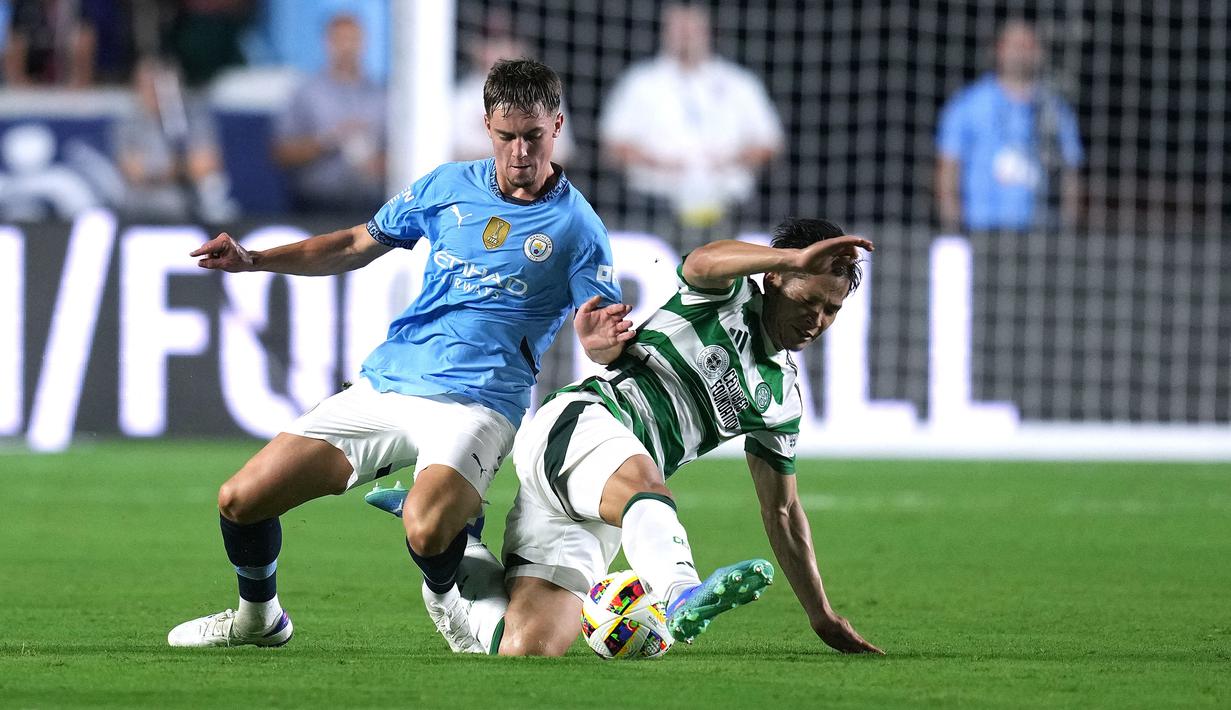 Pemain Glasgow Celtic,  Tomoki Iwata, berebut bola dengan pemain Manchester City, Jacob Wright, pada laga uji coba di Stadion Kenan Memorial, Rabu (24/7/2024). (AFP/Grant Halverson)