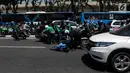 Sejumlah pengendara bergotong royong mengangkat sepeda motor mereka melewati pembatas jalan untuk berpindah jalur di kawasan Ridwan Rais, Jakarta, Rabu (21/8/2019). Pengendara motor tersebut berpindah jalur disebabkan tidak sabar menunggu kemacetan. (Liputan6.com/Johan Tallo)