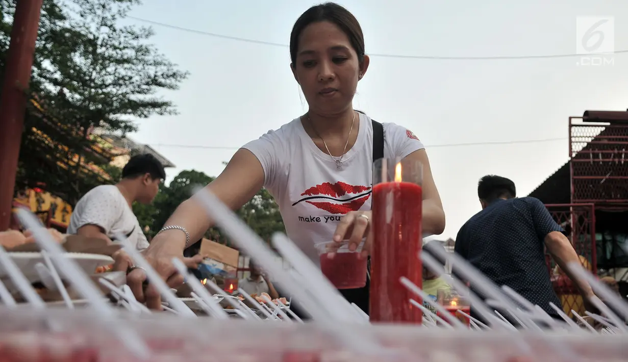 Seorang wanita menyiapkan hidangan berbuka puasa di Vihara Dharma Bhakti, Glodok, Jakarta, Rabu (30/5). Acara yang pertama kali digelar pada Ramadan tahun ini sebagai kegiatan untuk menjalin keharmonisan antar-umat beragama. (Merdeka.com/Iqbal S. Nugroho)
