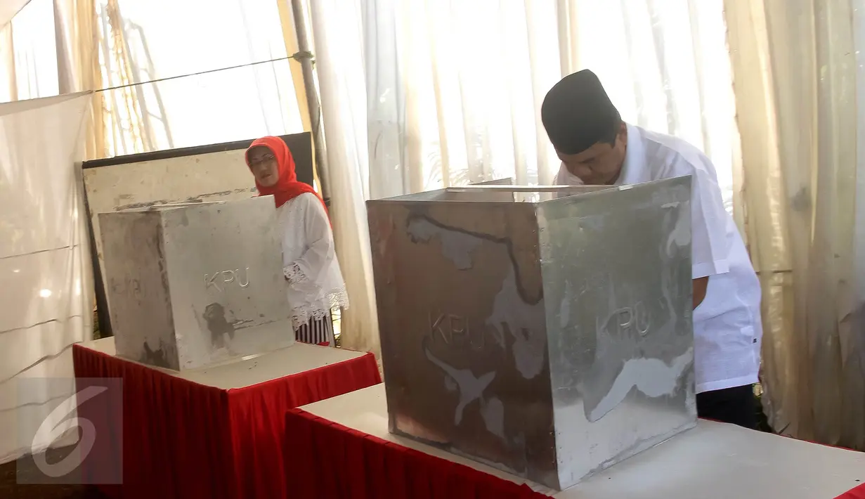Calon Walikota Tangerang Selatan nomor urut 2 Arsid beserta istri mencoblos surat suara di bilik saat menggunakan hak pilihnya di TPS 31 Kelurahan Pondok Benda, Tangsel, Rabu (9/12). (Liputan6.com/Fery Pradolo)