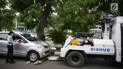 Mobil Dinas Perhubungan bersiap menderek kendaraan yang terjaring parkir liar di kawasan Pasar Baru, Jakarta, Kamis (14/12). Meskipun sering ditertibkan, namun masih banyak pengendara yang nekat parkir sembarangan. (Liputan6.com/Immanuel Antonius)
