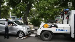 Mobil Dinas Perhubungan bersiap menderek kendaraan yang terjaring parkir liar di kawasan Pasar Baru, Jakarta, Kamis (14/12). Meskipun sering ditertibkan, namun masih banyak pengendara yang nekat parkir sembarangan. (Liputan6.com/Immanuel Antonius)