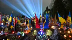 Sebuah pencahayaan simbolis yang disebut "Ray of Memory" terlihat di atas makam tentara Ukraina, Pemakaman Lychakiv, Lviv pada 23 Februari 2024. (YURIY DYACHYSHYN/AFP)