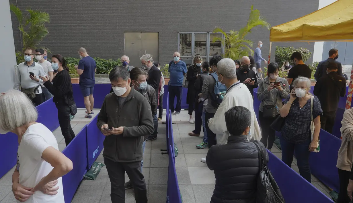 Antrean orang-orang di luar pusat vaksinasi untuk BioNTech di Hong Kong pada Rabu (24/3/2021). Hong Kong untuk sementara menangguhkan penggunaan vaksinasi corona Covid-19 Pfizer/BioNTech karena laporan kerusakan pada pengemasan botol vaksin. (AP Photo/Vincent Yu)