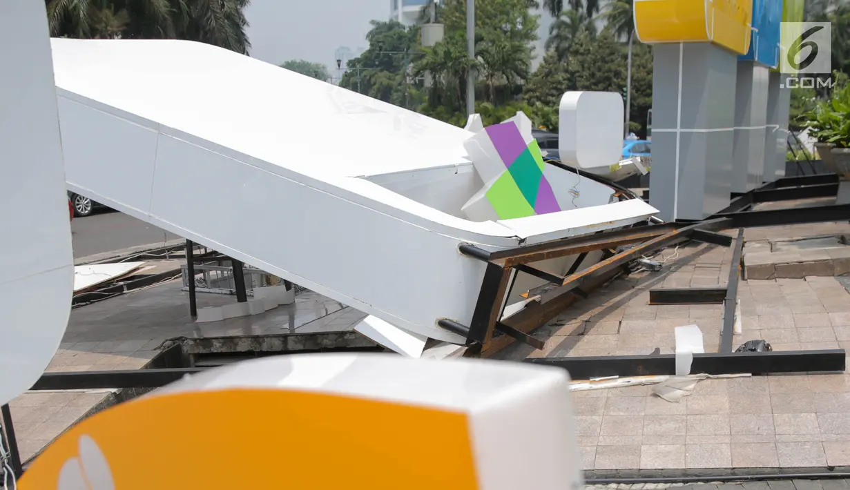 Kondisi besi penyangga papan sosialisasi Asian Games 2018 yang roboh akibat hujan angin di Bundaran HI, Jakarta, Senin (11/9). (Liputan6.com/Faizal Fanani)