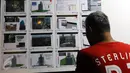 Warga melihat gambar proses pembongkaran gedung Bank Panin di Bintaro, Pondok Aren, Tangerang Selatan, Jumat (14/10). Pembongkaran tersebut menggunakan teknik pembebanan yang akan ditimpakan dari bagian atas gedung. (Liputan6.com/Helmi Afandi)